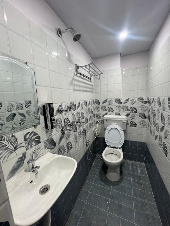Minimalist tiled bathroom with a hanging white towel and modern fixtures.